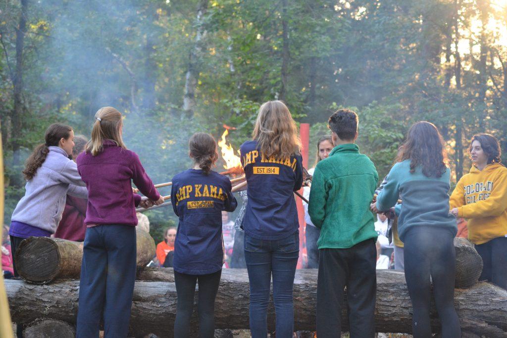 Campers bonding around a campfire at a summer camp in Minnesota
