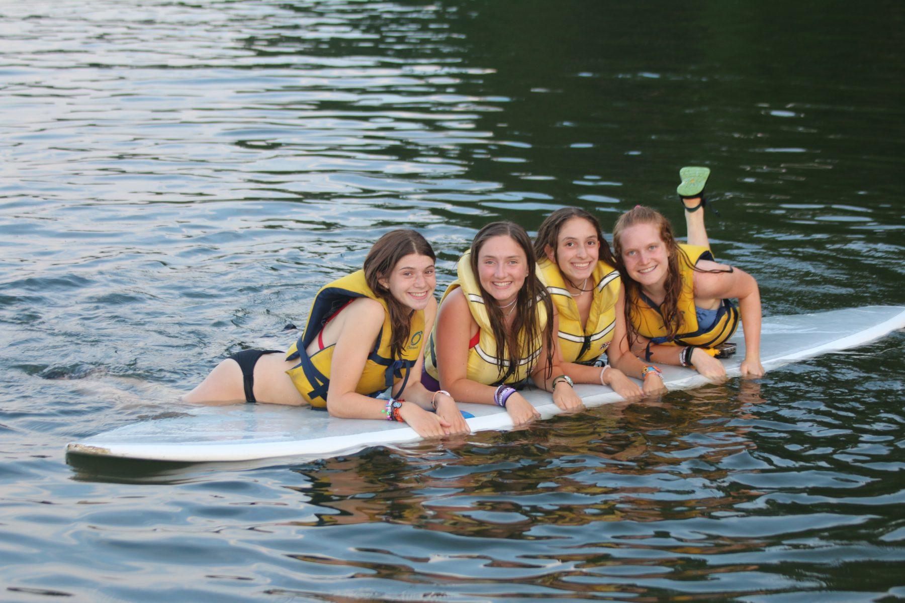 Girls on a surfboard at Kamaji summer camp for girls