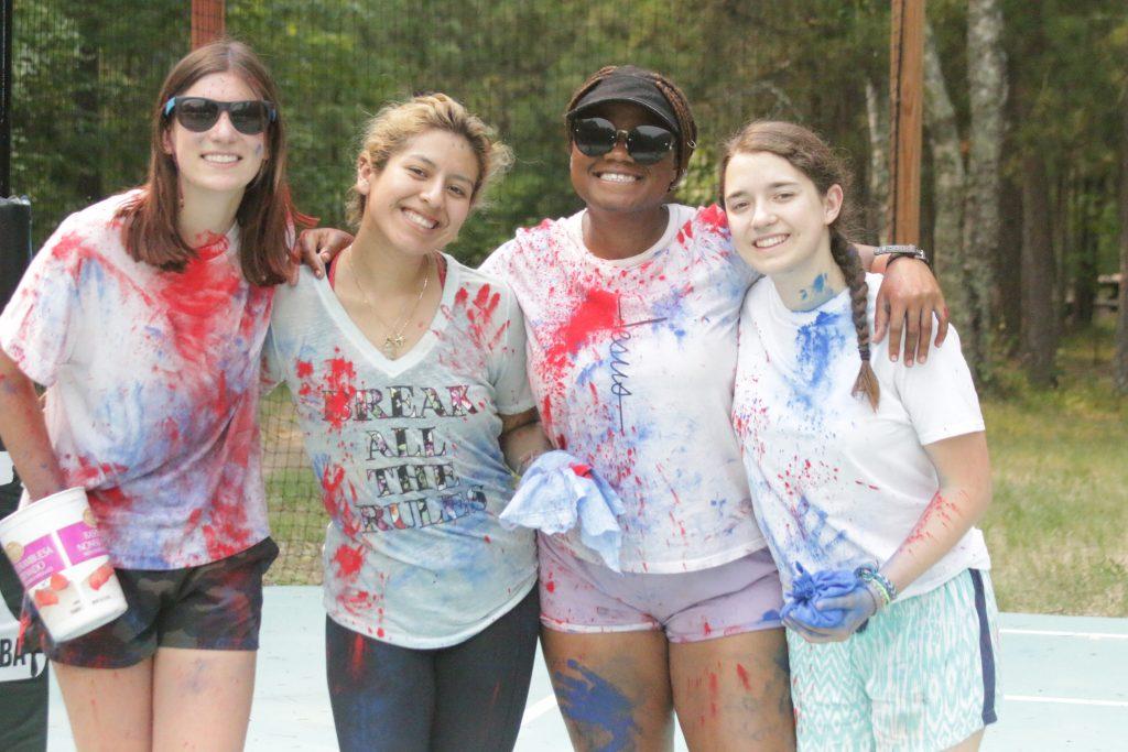 A diverse group of girls engaging in a teamwork activity at summer camp