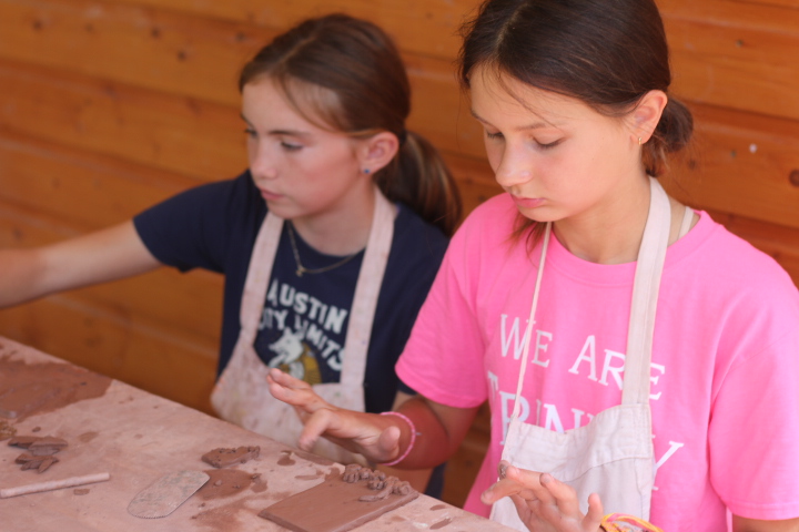 Campers engaging in diverse artistic activities such as painting, dancing, and crafts